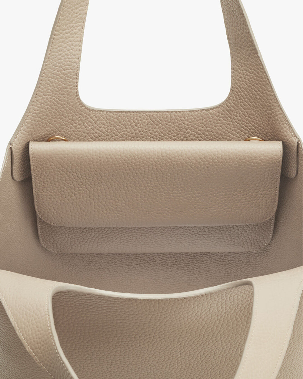 System Flap Bag Close-up of a handbag with a textured surface and handles.