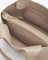 Open handbag showing inner compartments and a zipper.