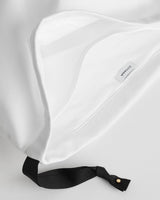 Close-up of a fabric bag with a label and a strap attachment.