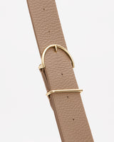 Leather strap with metal buckle against a plain background.