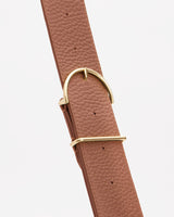 Leather strap with metal buckle against a plain background