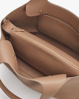 Open handbag showing interior with zipper compartment.