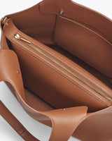 Open handbag showing inner compartments and zippers.