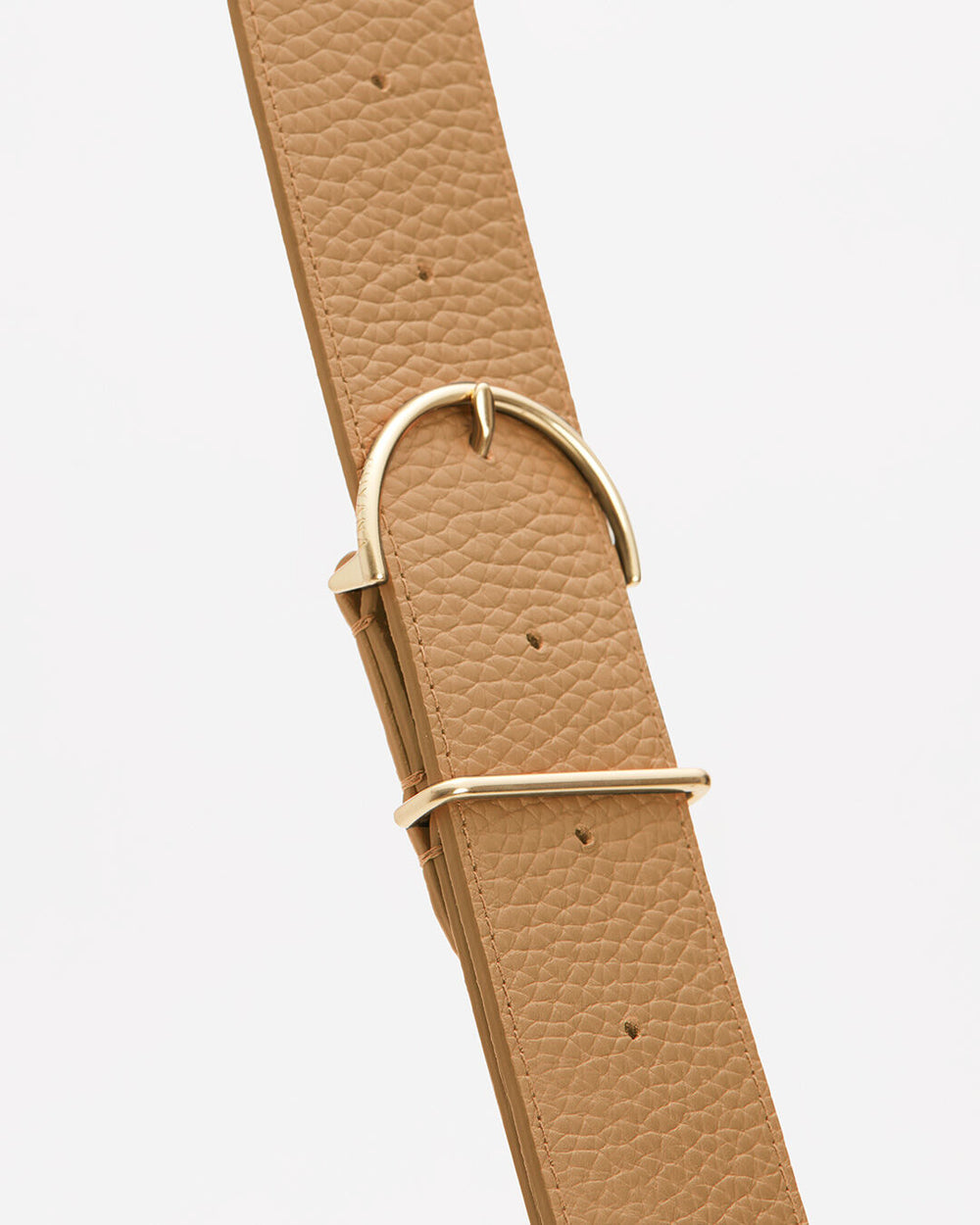 Close-up view of a textured strap with a metal buckle and loop.