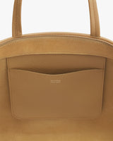 Close-up of a handbag with a front pocket and brand logo.