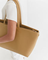 Person carrying a large tote bag over one shoulder