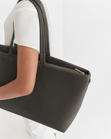 Person carrying a large handbag over their shoulder.
