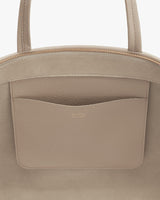 Close-up of a handbag with a front pocket and zipper.