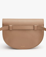 Small, textured crossbody bag with flap and front strap closure.