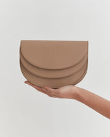 Hand holding a semi-circular layered purse