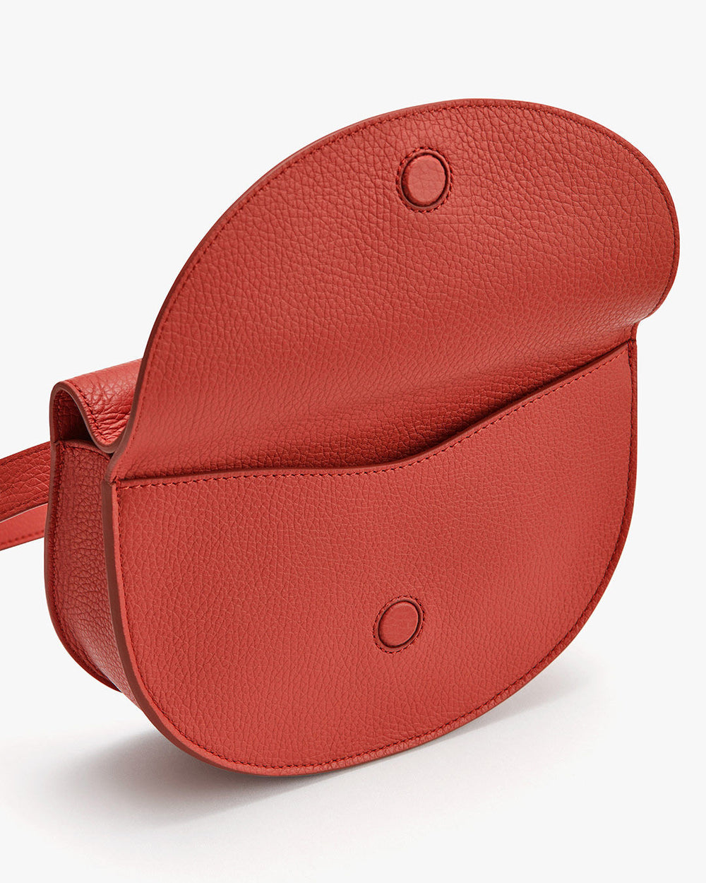 A small saddle-shaped shoulder bag with a flap closure and visible snap buttons.