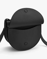 Round shoulder bag with flap closure and strap.
