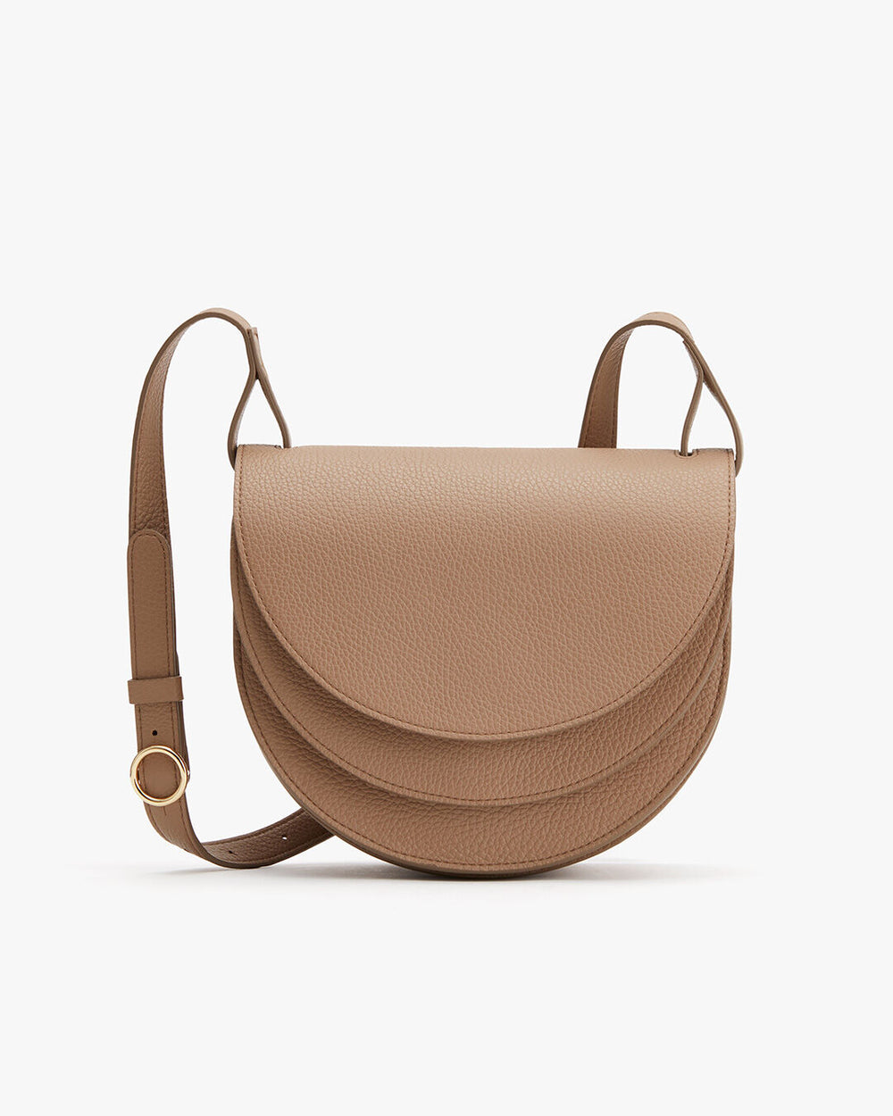 Handbag with a flap front and adjustable strap on a plain background.