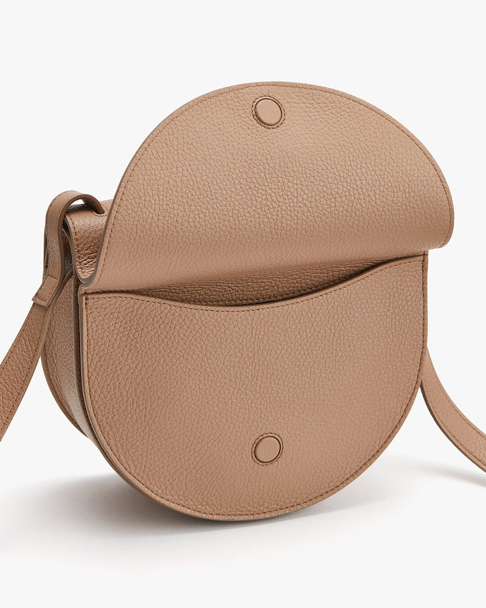 Round shoulder bag with a flap closure and an adjustable strap.
