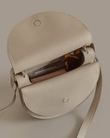Small handbag open with sunglasses peeking out.