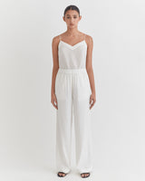 Woman standing in a jumpsuit with hands at her sides.