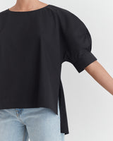 Person wearing a short-sleeve top and jeans.