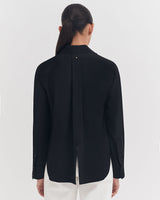 Person seen from behind wearing a formal jacket and pants.