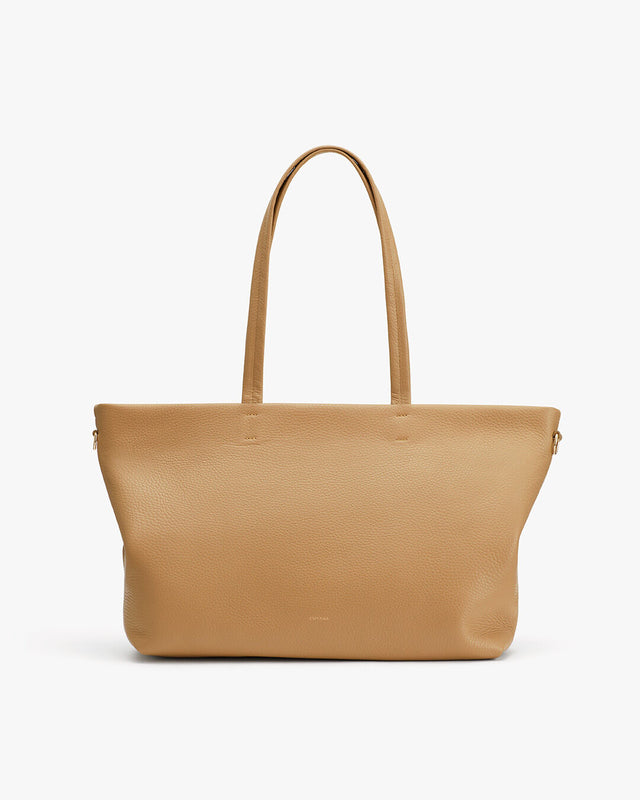 Leather tote bag on a plain background.