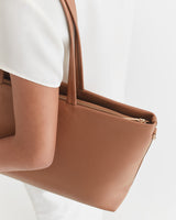 Person carrying a large handbag on their shoulder