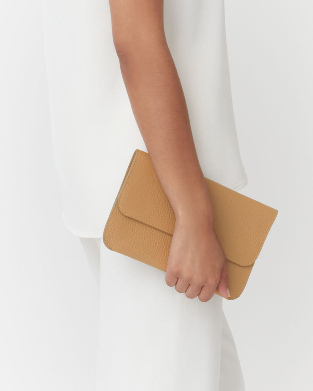 System Flap Bag Person holding a clutch bag against their side