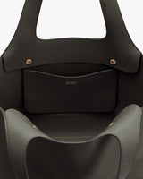 Open handbag with an exterior pocket and visible brand name.