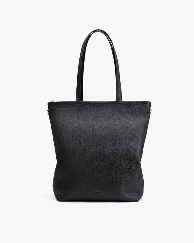 Upright tote bag with two handles and a brand label near the bottom.