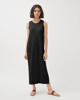 Woman standing in a sleeveless dress and sandals