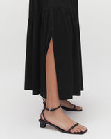 Person wearing sandals and a dress with a high side slit.