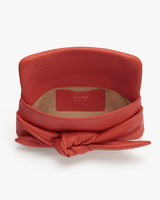 Open leather handbag with a knotted detail on the front.