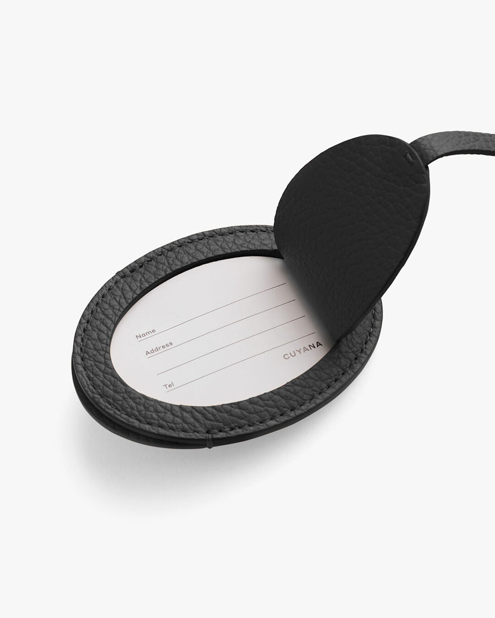 Open round luggage tag with a paper insert for contact information.