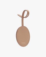 Oval-shaped tag with a loop and brand name embossed.
