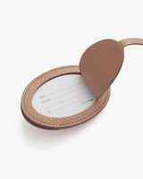 Open oval luggage tag with a name card inside and a strap attached.