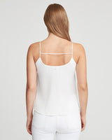 Woman seen from behind wearing a sleeveless top and pants.