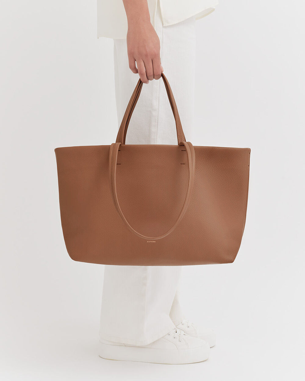 Small Easy Tote Person holding a large handbag standing.