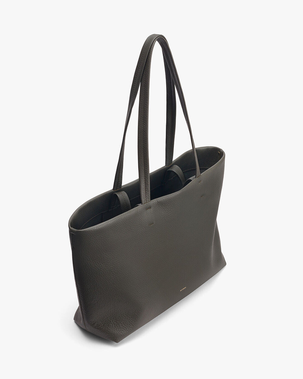 Leather tote bag with dual handles standing upright.