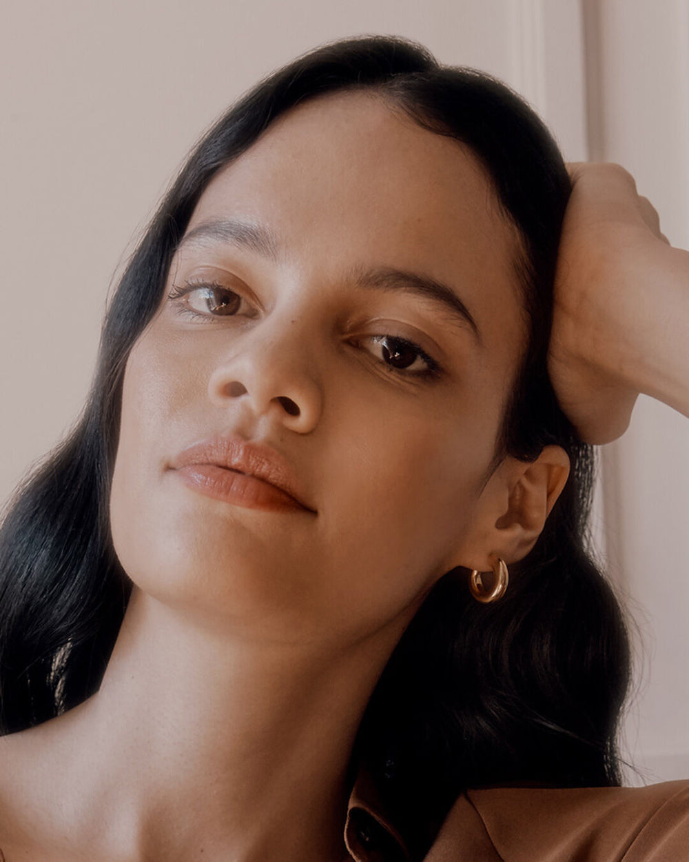 Close-up of a woman resting her head on her hand.