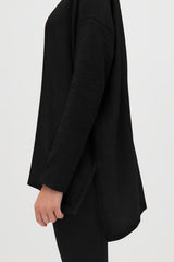 Close-up of a person wearing a long sleeve outfit viewed from the side.