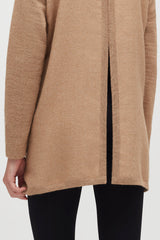 Close-up of a person wearing a coat and black pants.