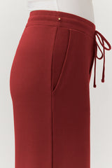 Close-up of a person wearing pants with a drawstring detail on the side.