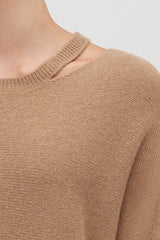 Close-up of a person wearing a sweater with a round neckline.