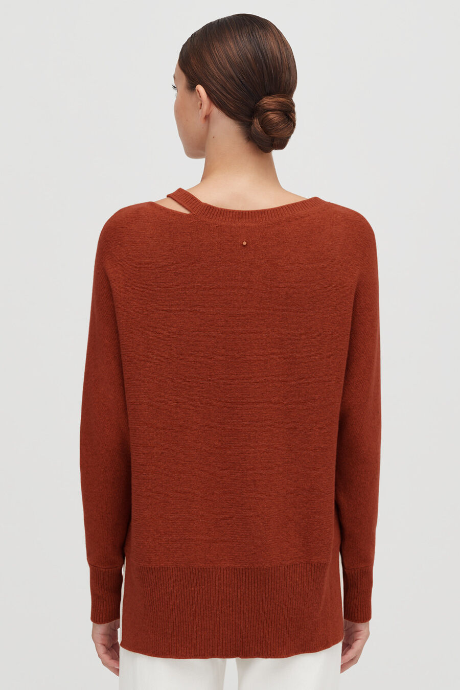 Recycled Cashmere Split-Neck Sweater Woman facing away, wearing a sweater and styled hair in a bun.