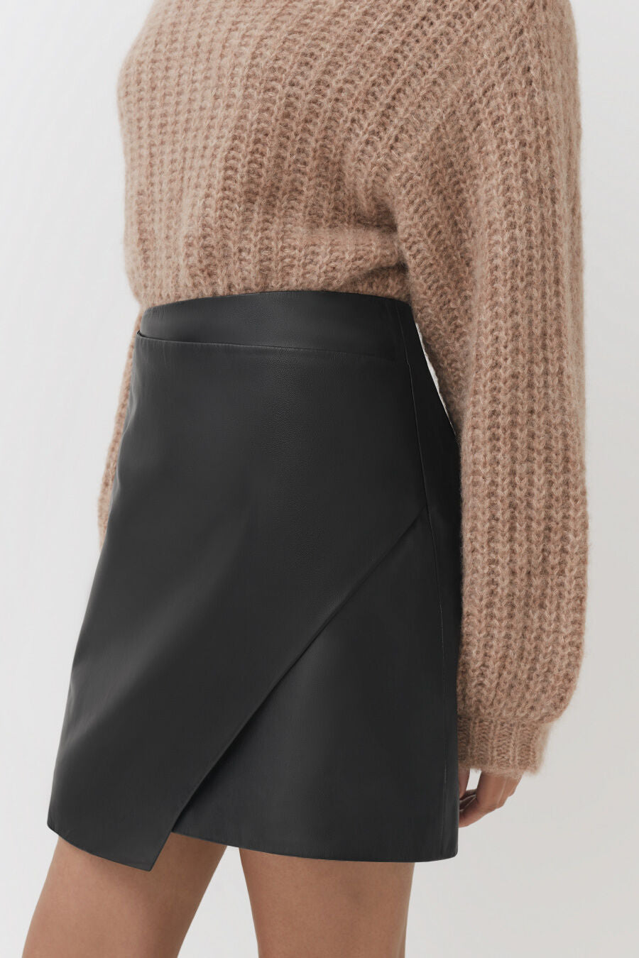Person wearing a sweater and an asymmetrical skirt.