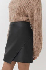 Person wearing a sweater and an asymmetrical skirt.