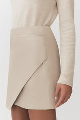 Woman in a skirt and sweater, side view focusing on skirt design.