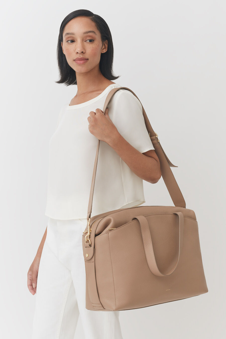 Overnight Bag Woman carrying a large shoulder bag standing indoors