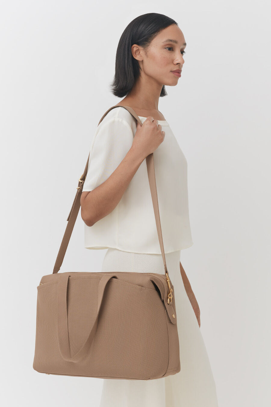 Woman walking with a shoulder bag.