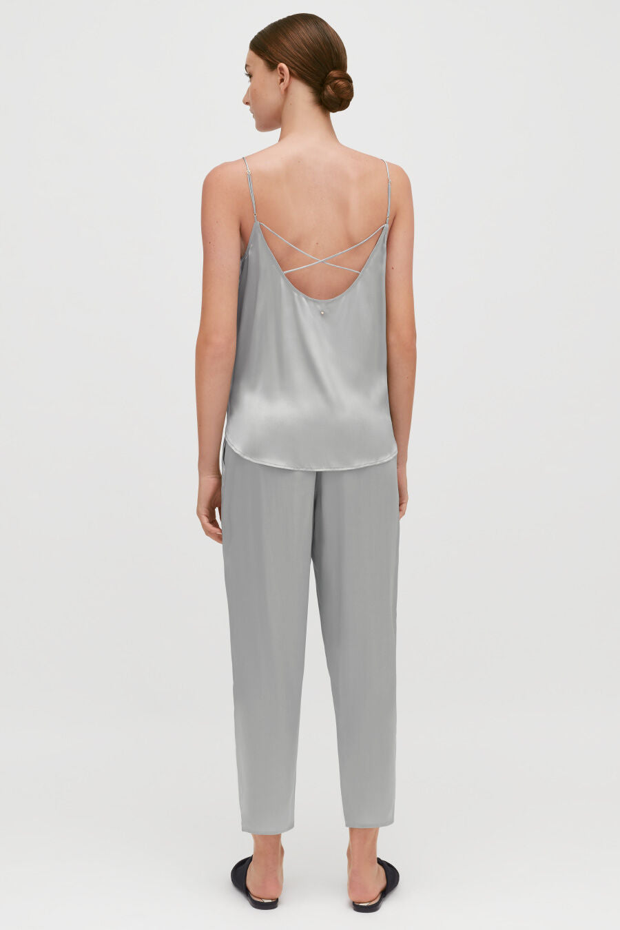 Washable Charmeuse Tapered Pant Woman standing facing away wearing a top with criss-cross back straps and pants.