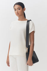Woman standing with a shoulder bag