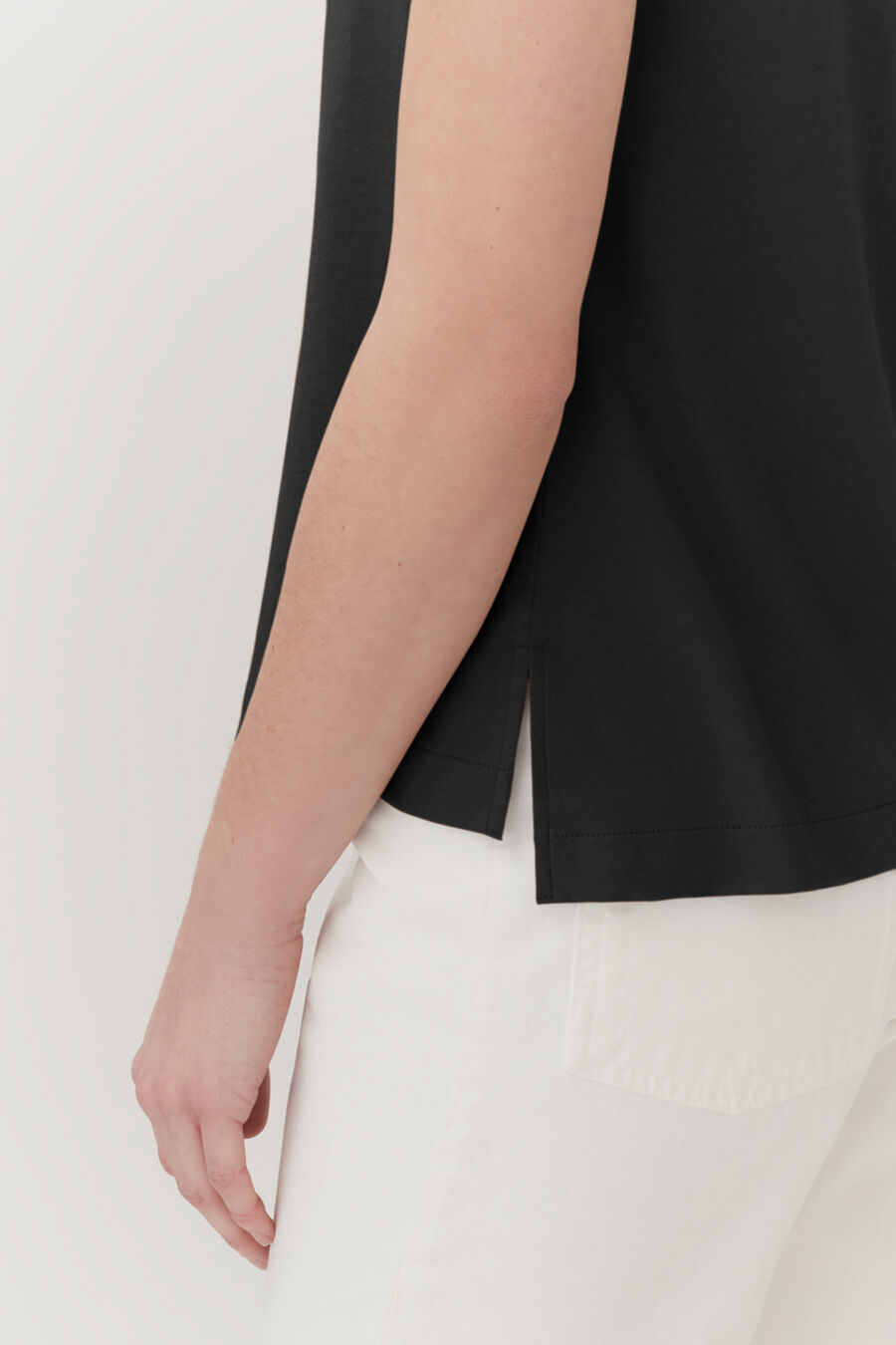 Person standing with side view showing only arm and torso.